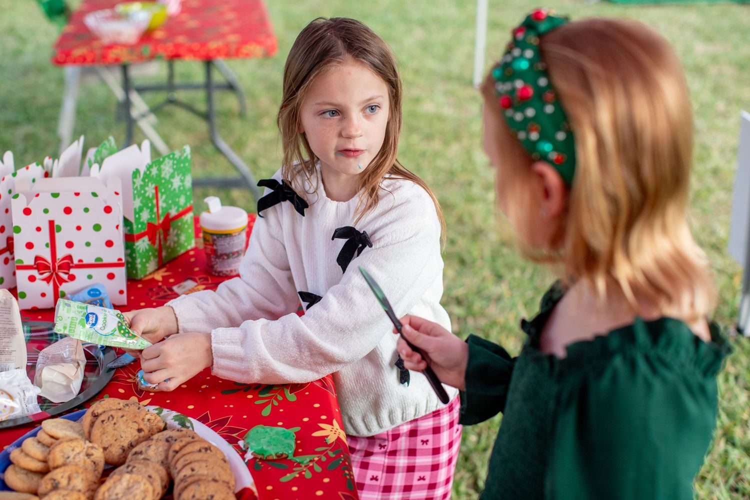 Children celebrating at a festive holiday party with wrapped presents and decorations.