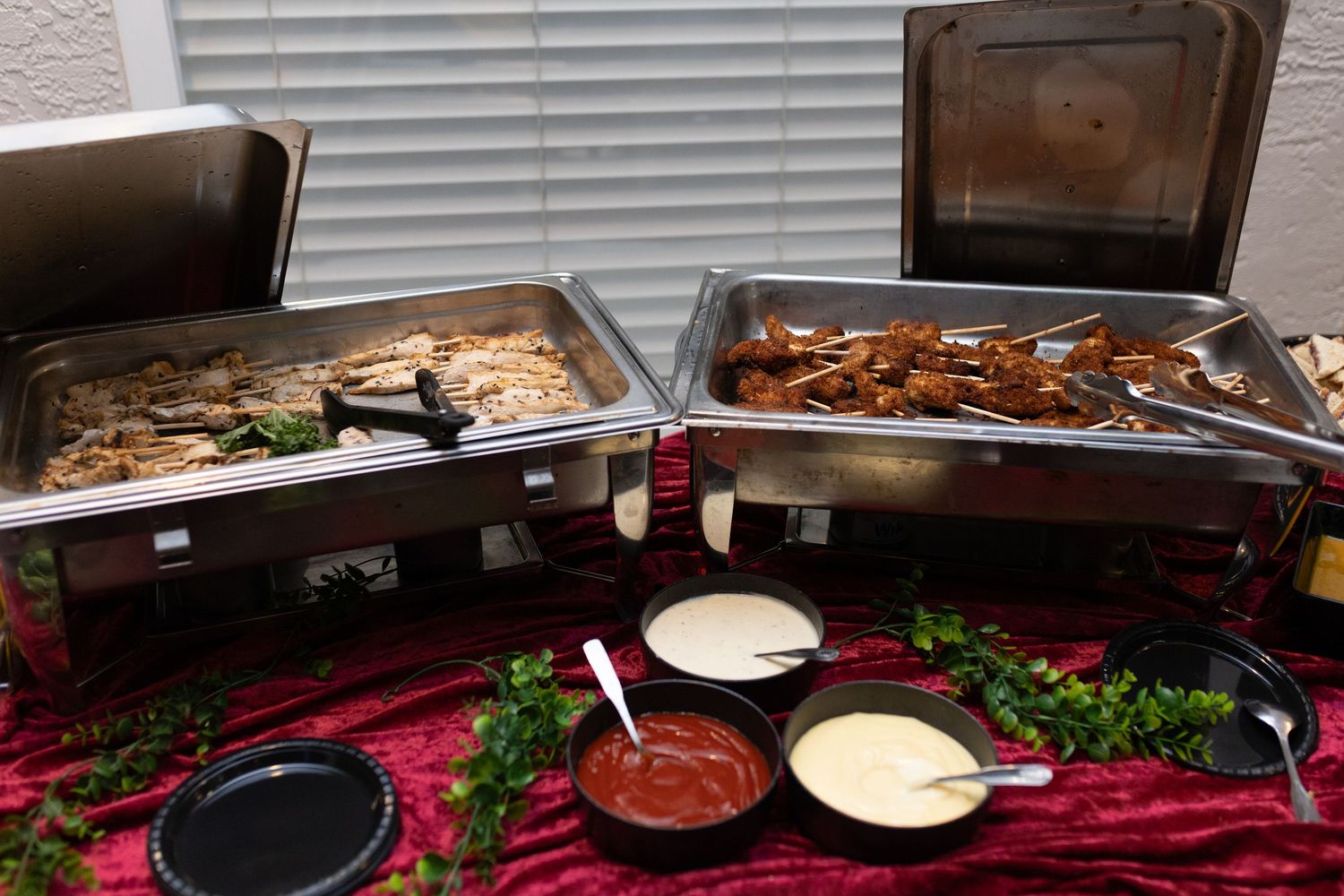 Catering spread with various appetizers and dishes on elegant serving platters.