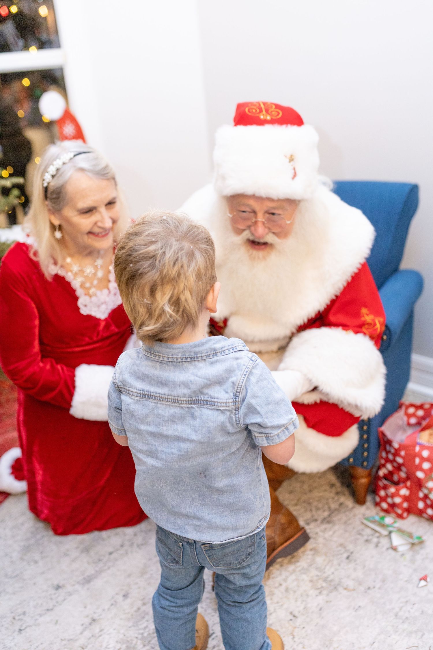Candid interaction during Christmas photo session with festive decorations.