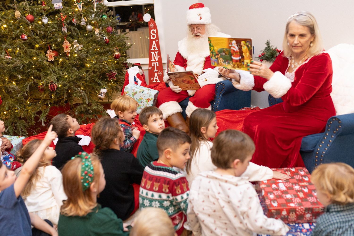 Children gather around Santa Claus at a festive Christmas party.