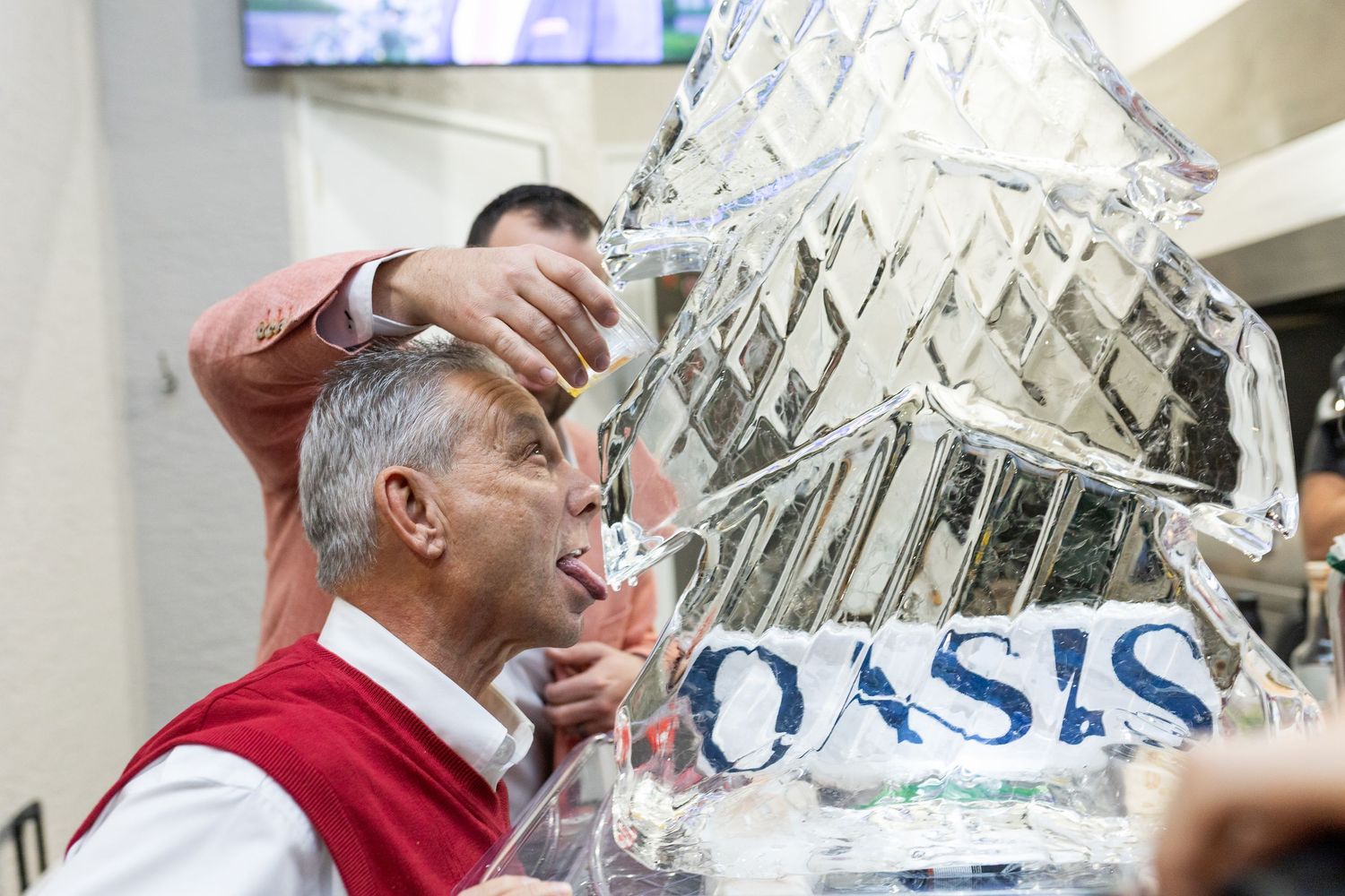 Guests admiring a large crystal ice sculpture display at a winter event.