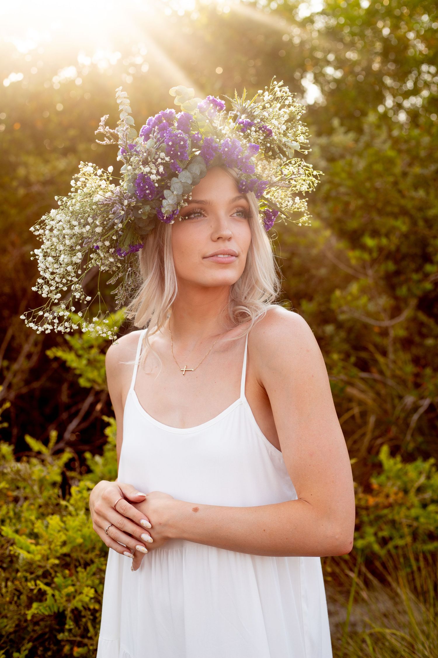 Summer portrait with baby's breath crown and white top in golden hour lighting.