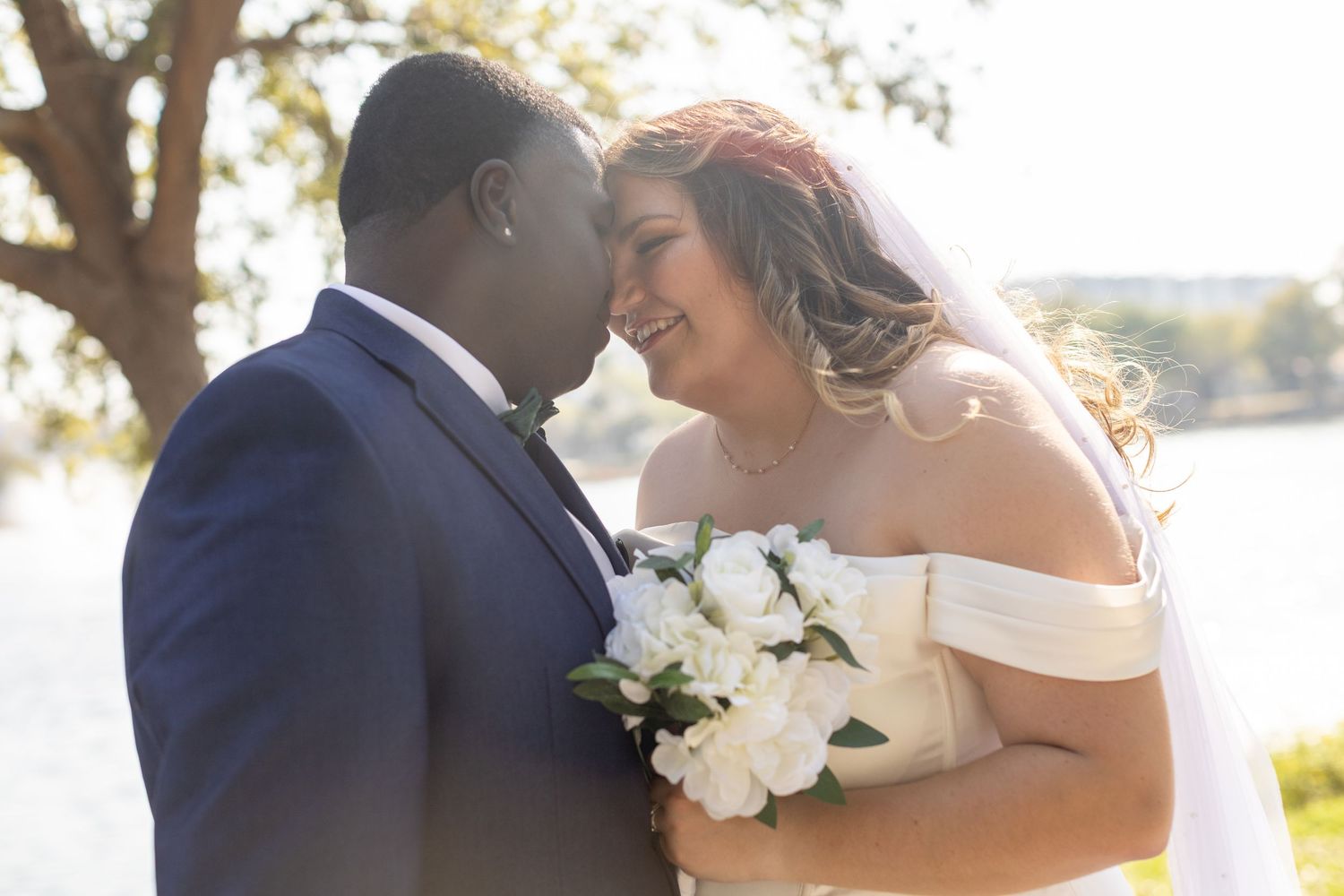 A romantic outdoor wedding moment with white flowers and natural sunlight.