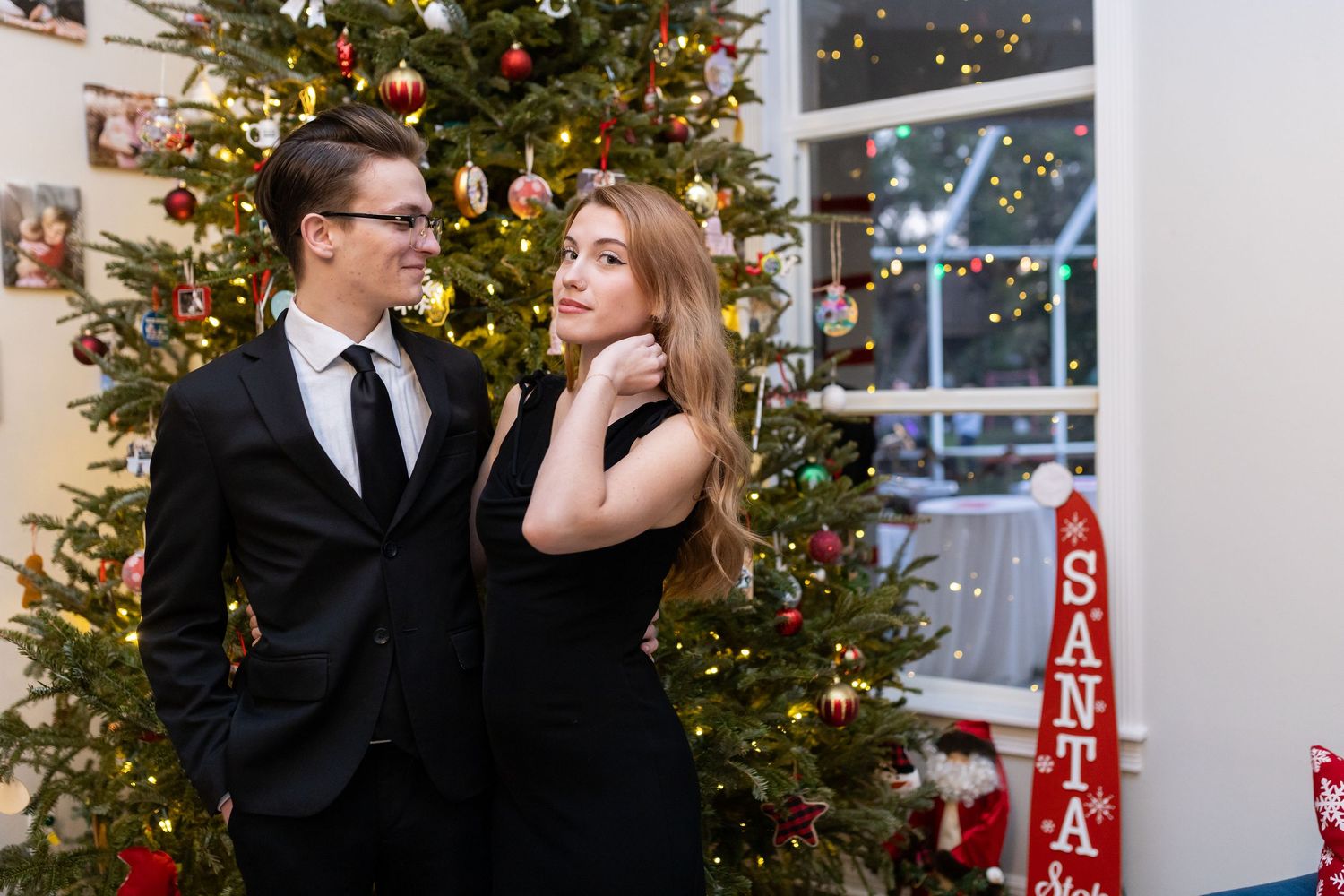 Holiday portraits in front of illuminated Christmas tree with festive decorations.