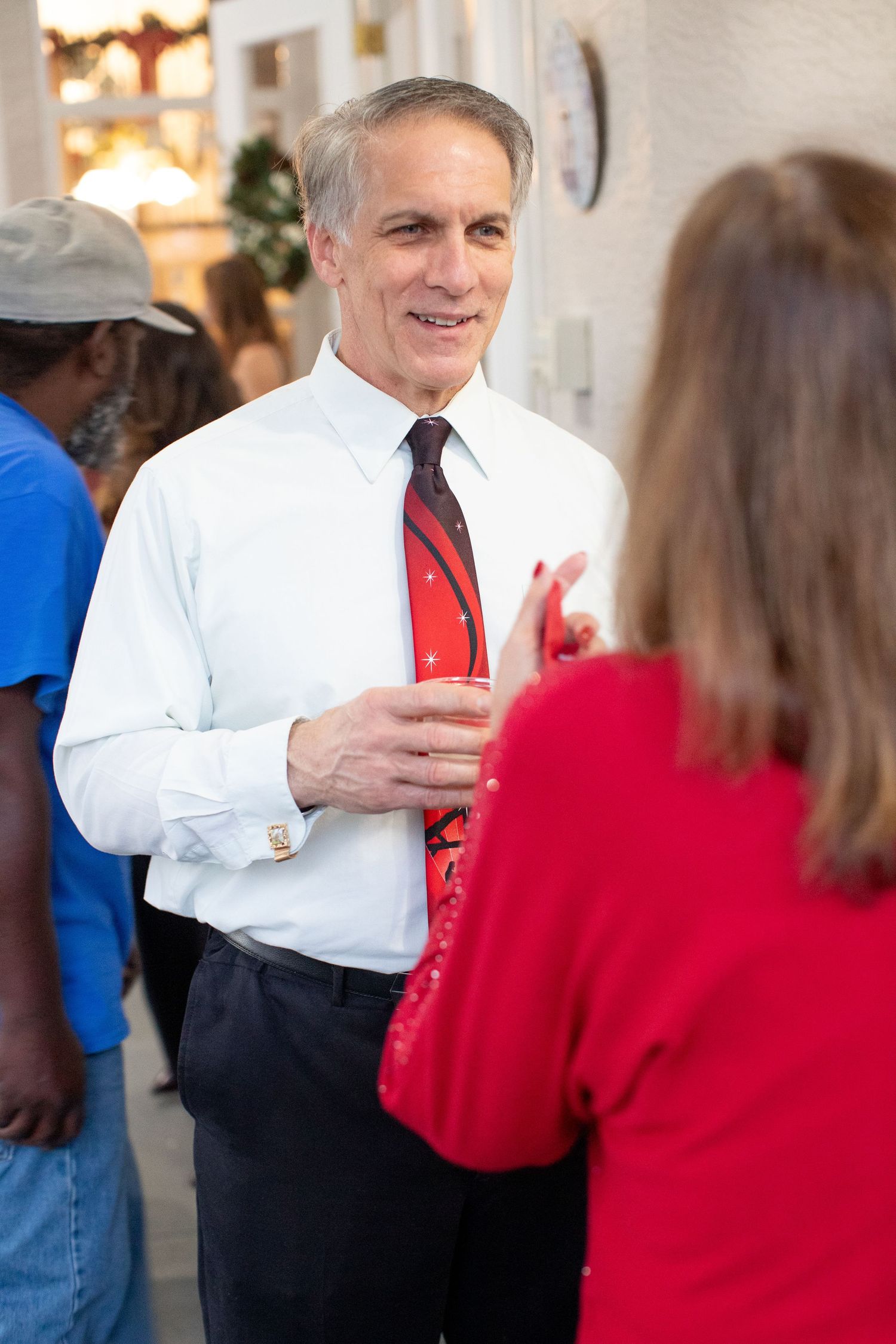 Professional event with attendees in business attire having conversations indoors.