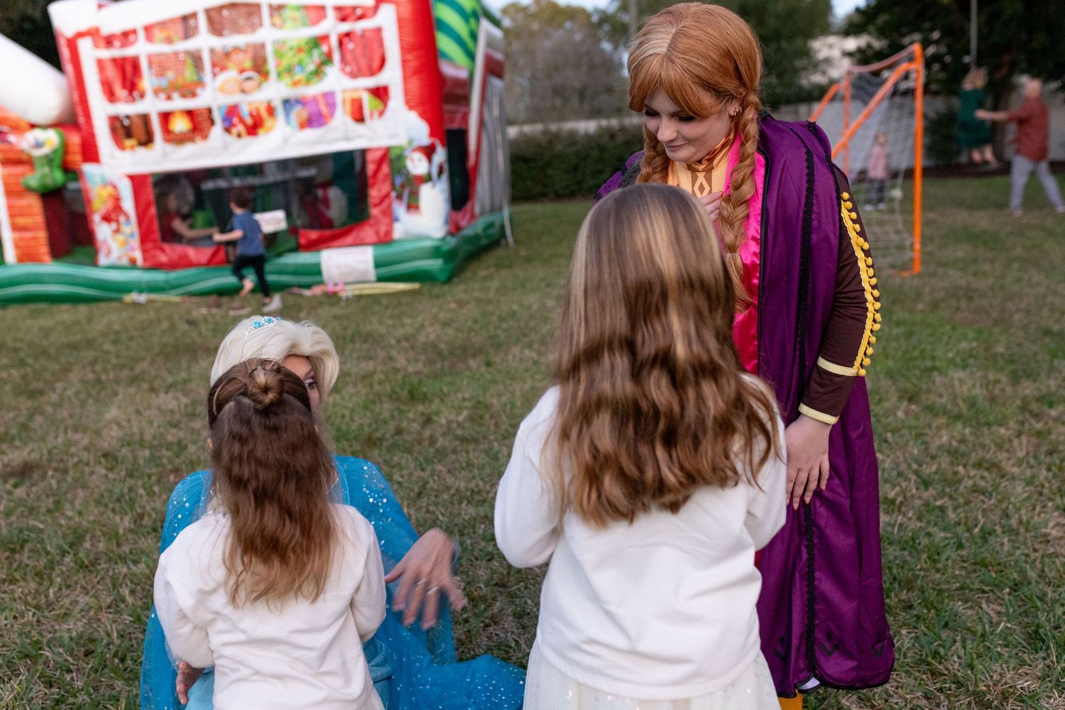 People in costumes having a conversation at an outdoor festival setting.