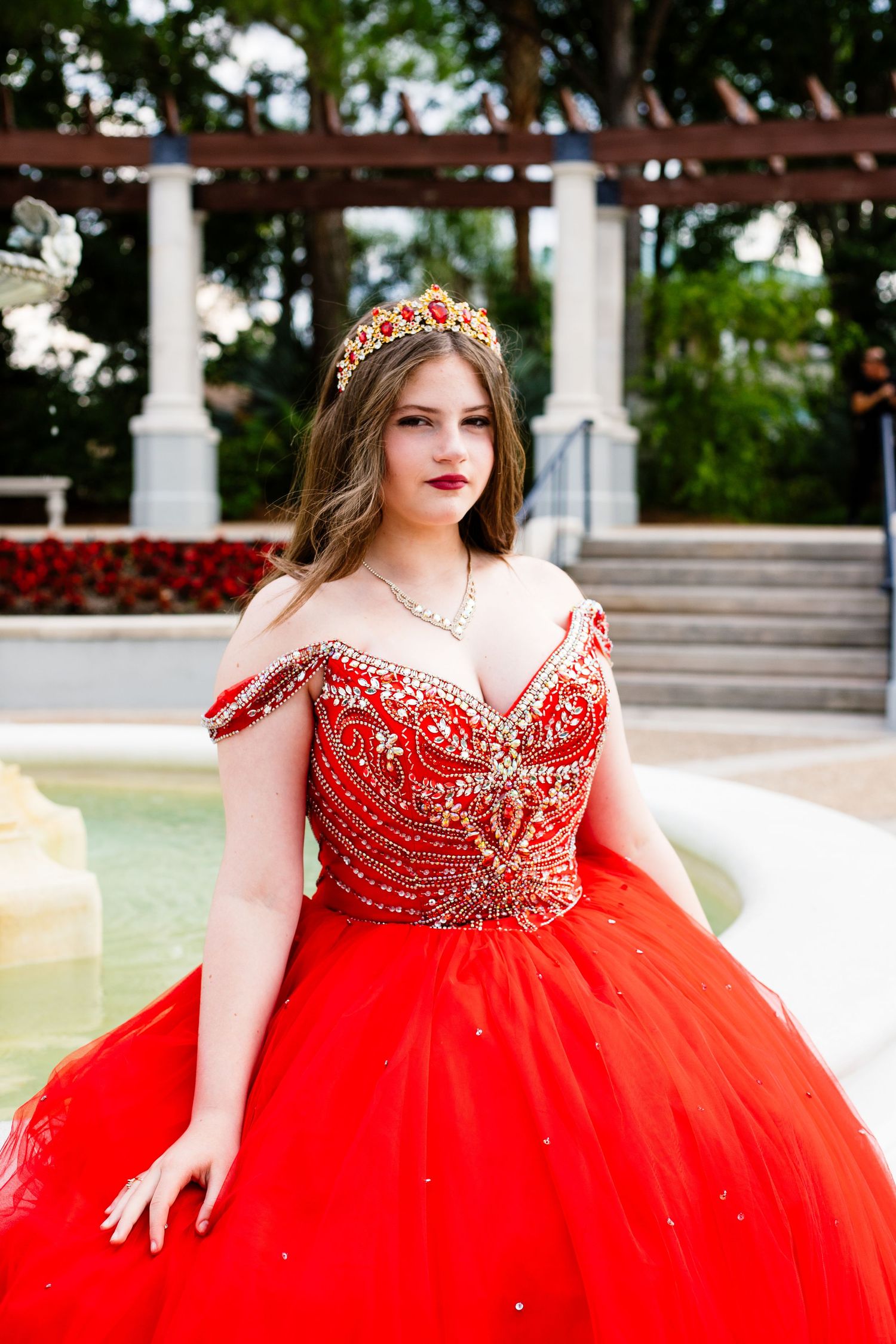 Stunning red crystal-embellished ballgown with sweetheart neckline photographed outdoors.