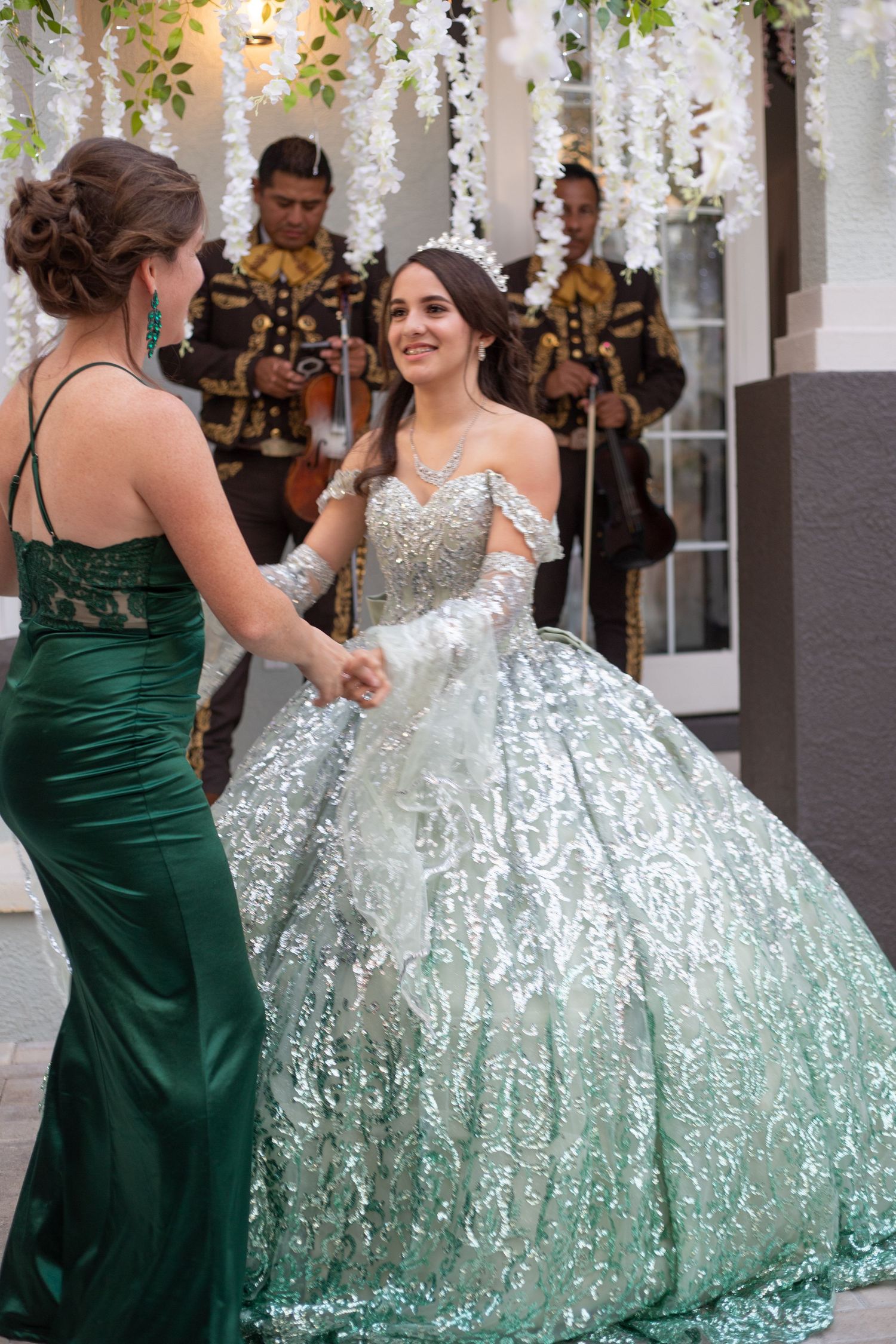 An elegant ball gown moment with a sparkling silver dress and hanging floral decorations.