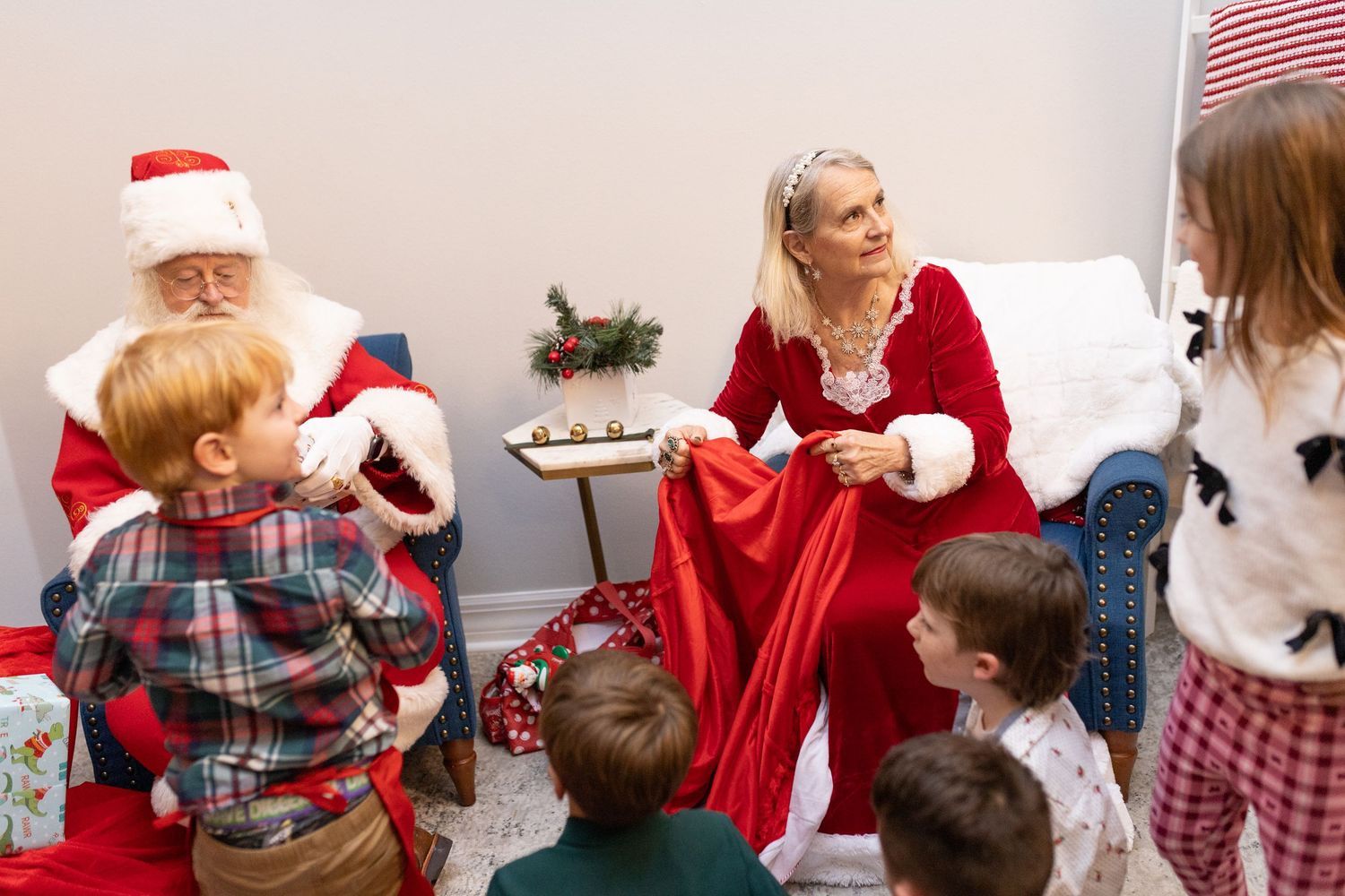 Holiday gathering with people in festive attire around a decorated room with an American flag visible.
