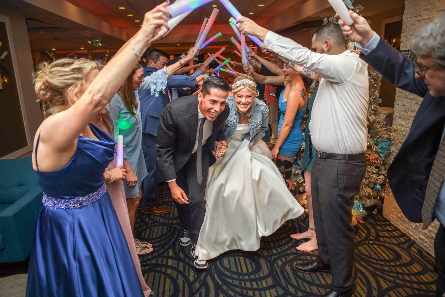Wedding guests form an arch tunnel with their arms for the couple to dance through.