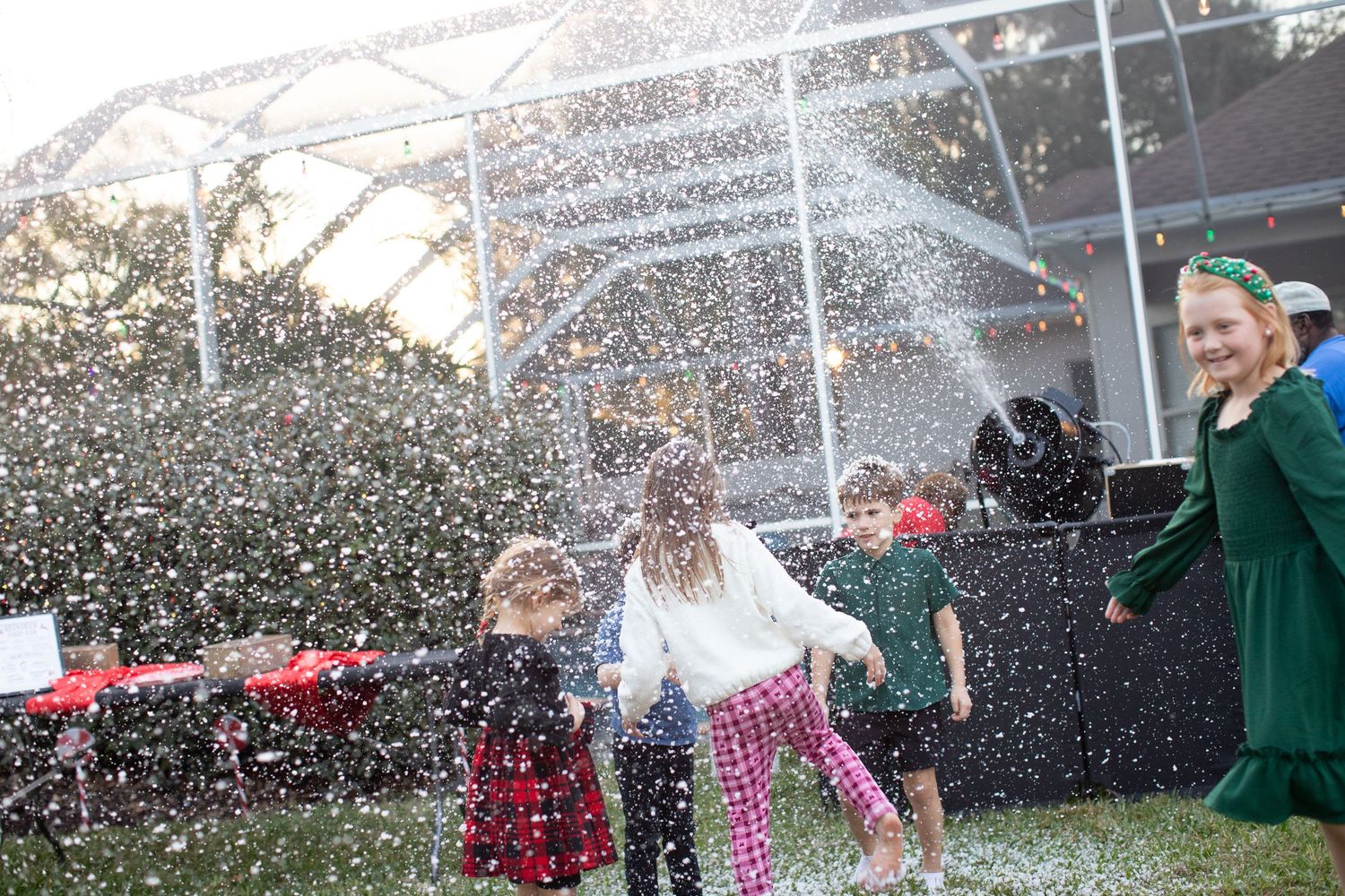 People playing in artificial snow at an outdoor winter celebration event.