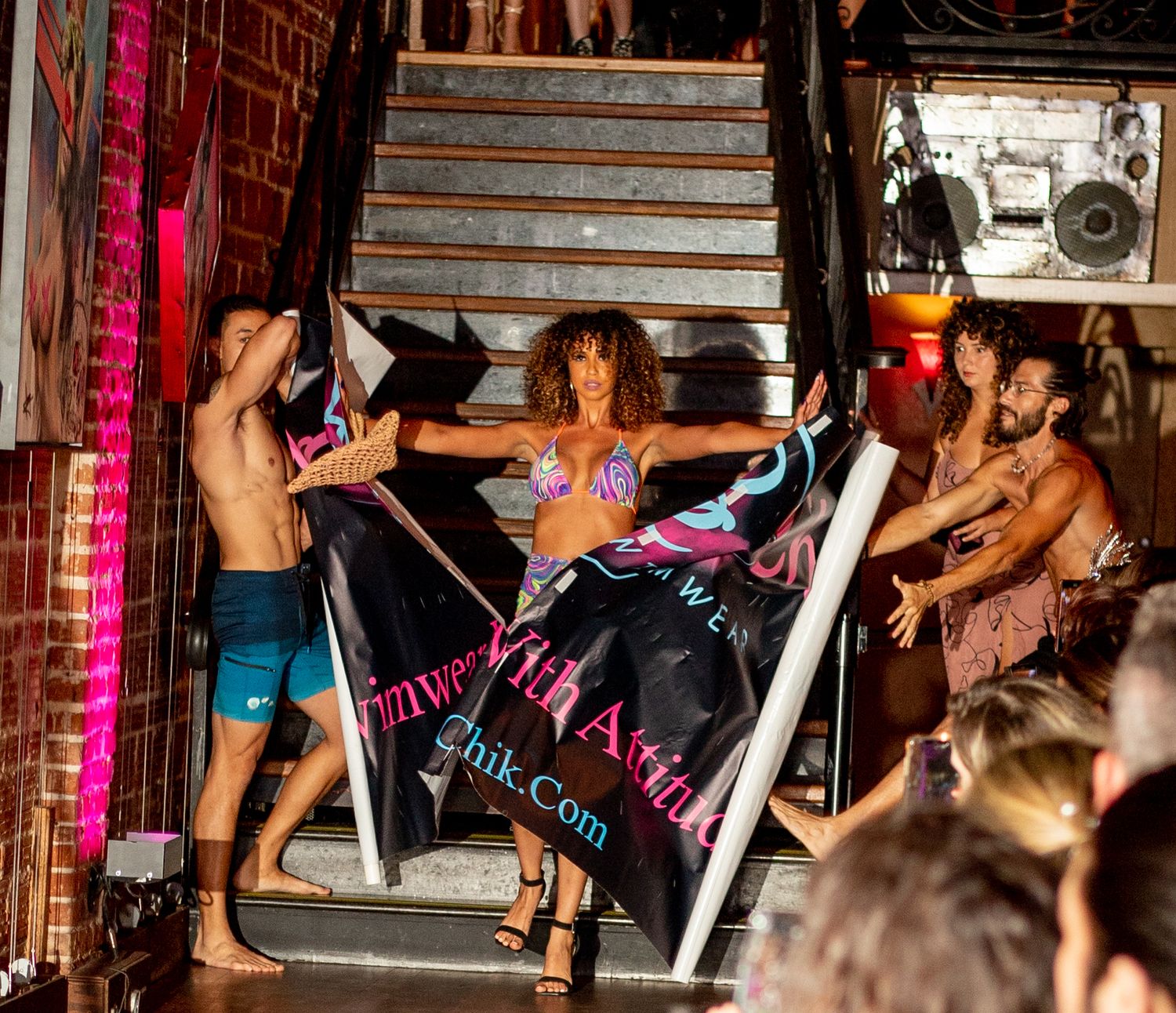 An energetic performance on stage with dancers and colorful lighting effects.