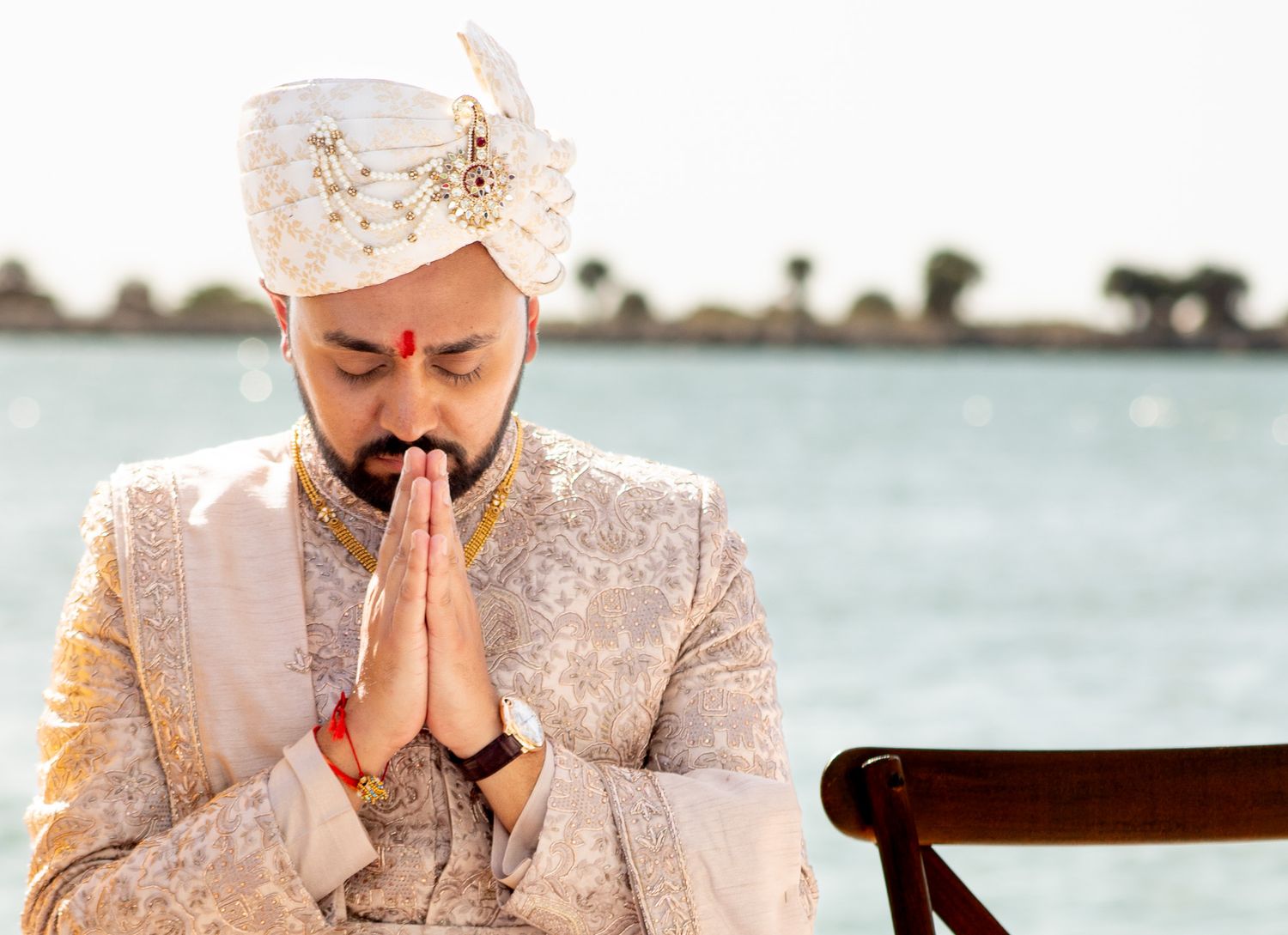 Traditional Indian groom in cream sherwani photographed during wedding ceremony.