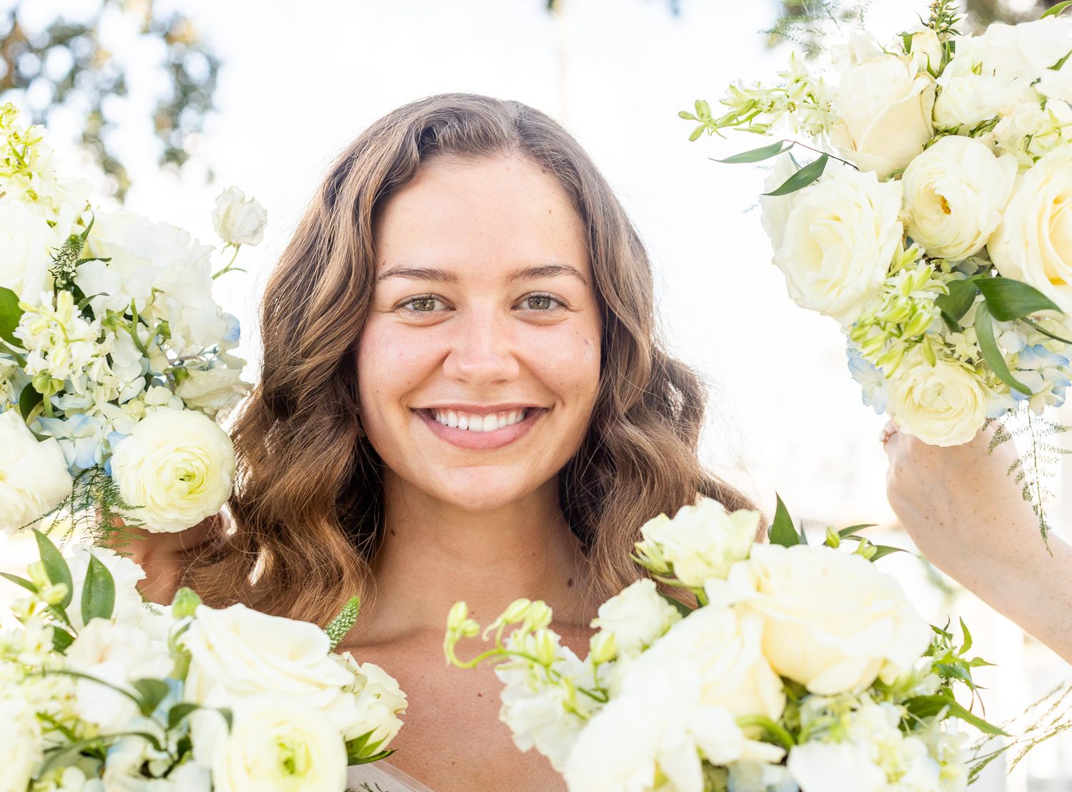 Bright and airy bridal portraits with white flowers and natural lighting.