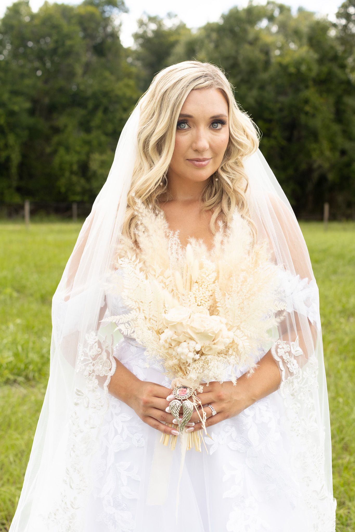 Bridal portraits showcasing detailed white dress and dried flower bouquet in natural setting.