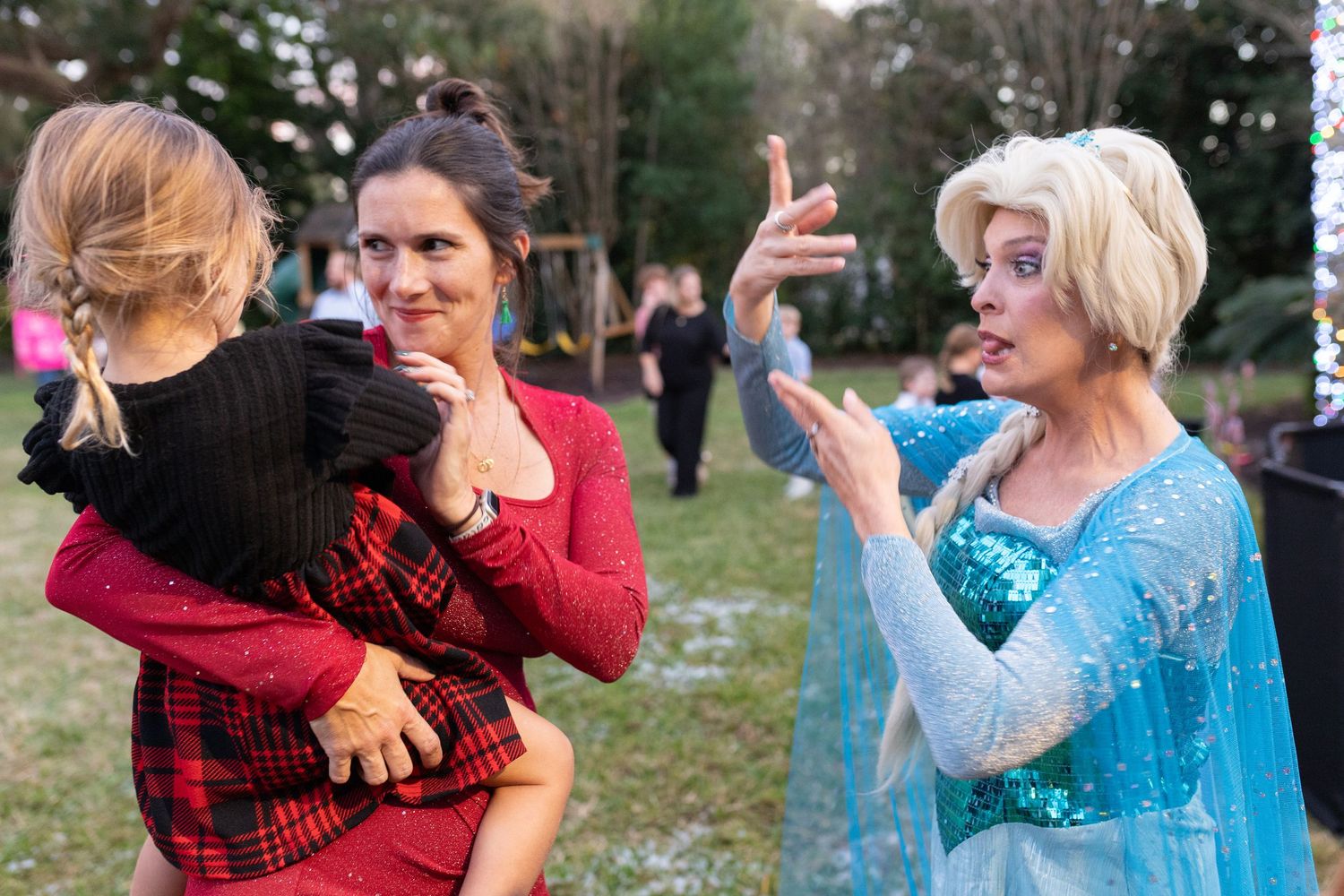A costumed performer interacts with guests at an outdoor winter celebration.