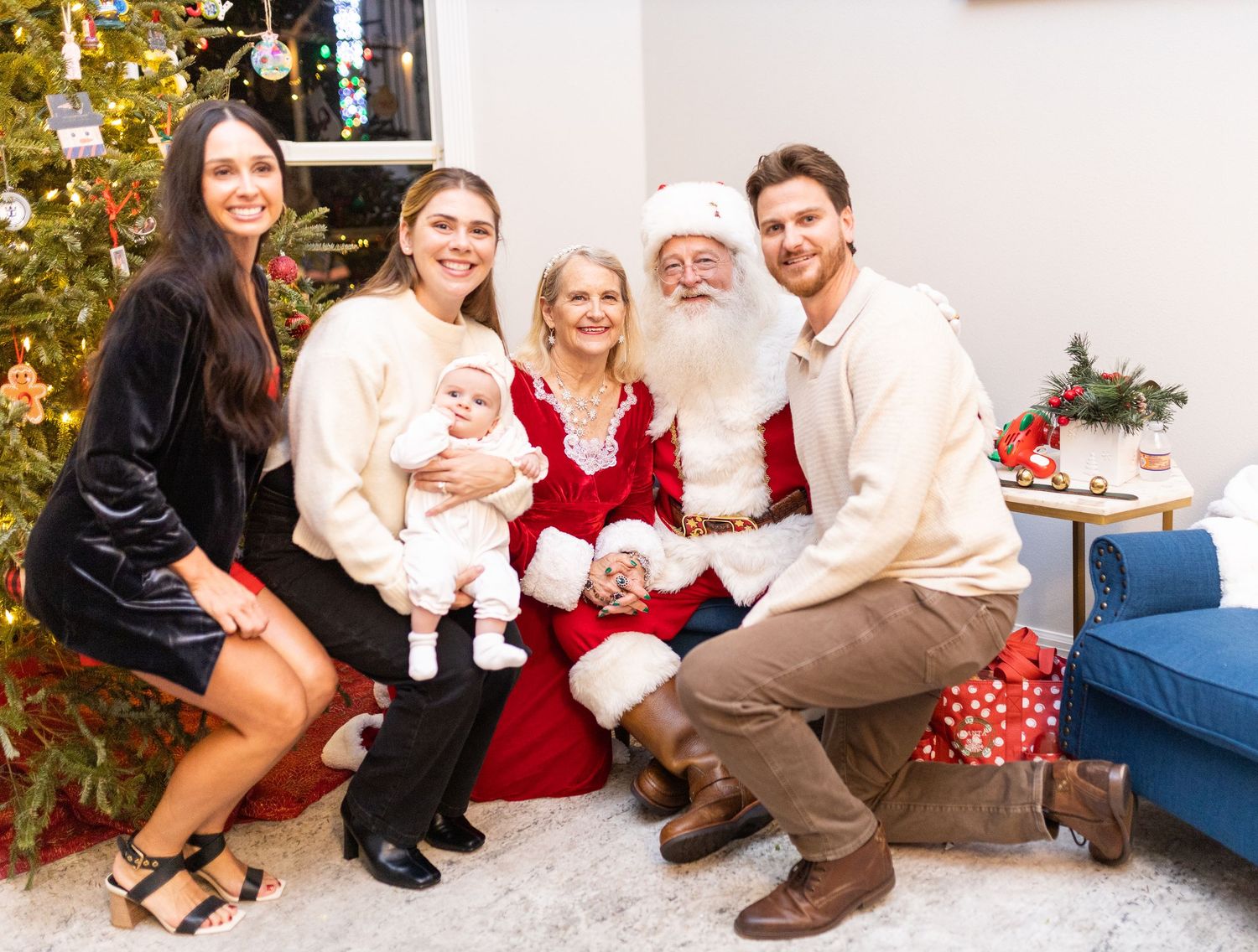 Holiday family photo session with Santa Claus and festive decorations in a cozy living room setting.