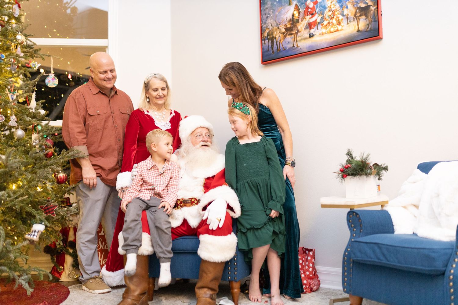 Holiday family portrait session with beautifully lit Christmas tree and festive home decorations.