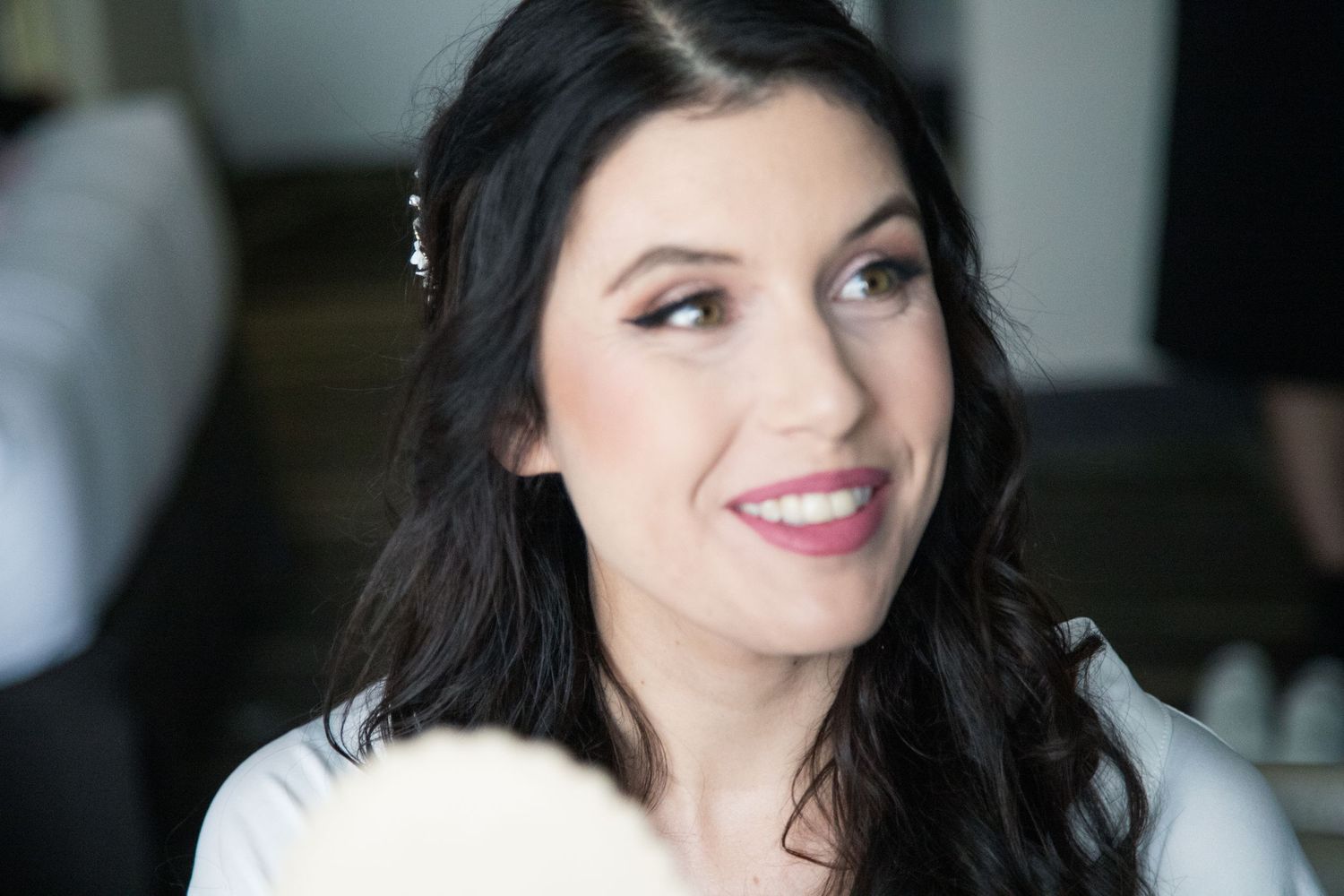 A close up beauty shot showing natural makeup and dark wavy hair.
