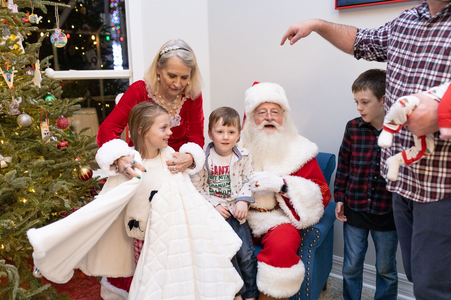 A festive family gathering around a decorated Christmas tree with holiday decor.
