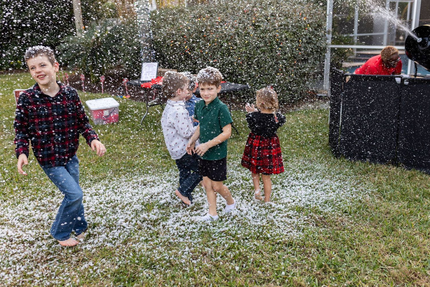 People playing in artificial snow during an outdoor winter celebration.