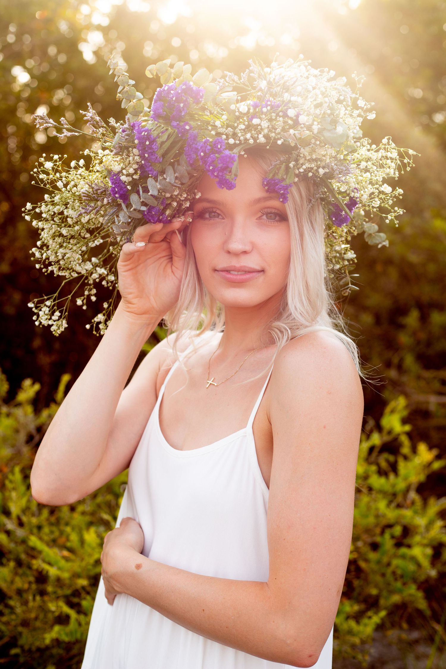 Dreamy summer portrait with delicate flower crown in warm evening light.
