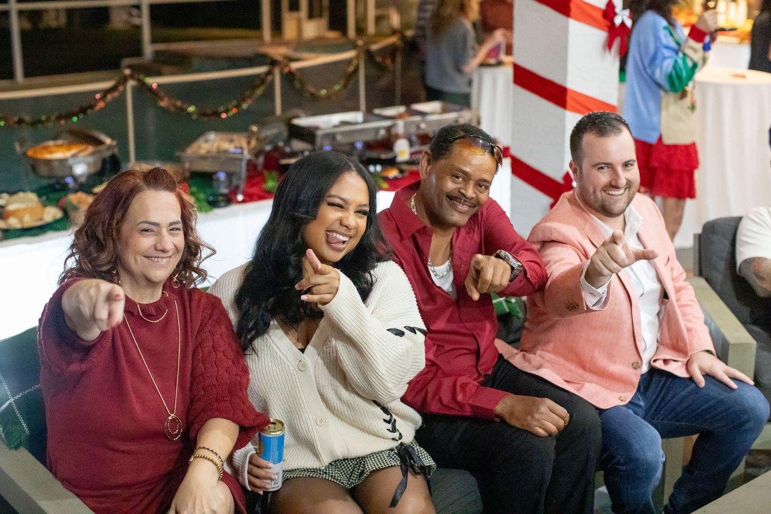 Friends enjoying drinks and laughing together during holiday celebration.