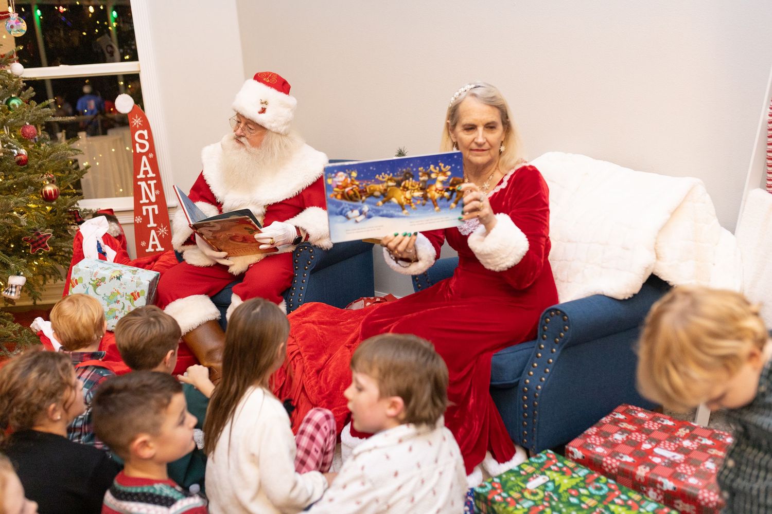 Group of children receive presents during holiday celebration with Santa.