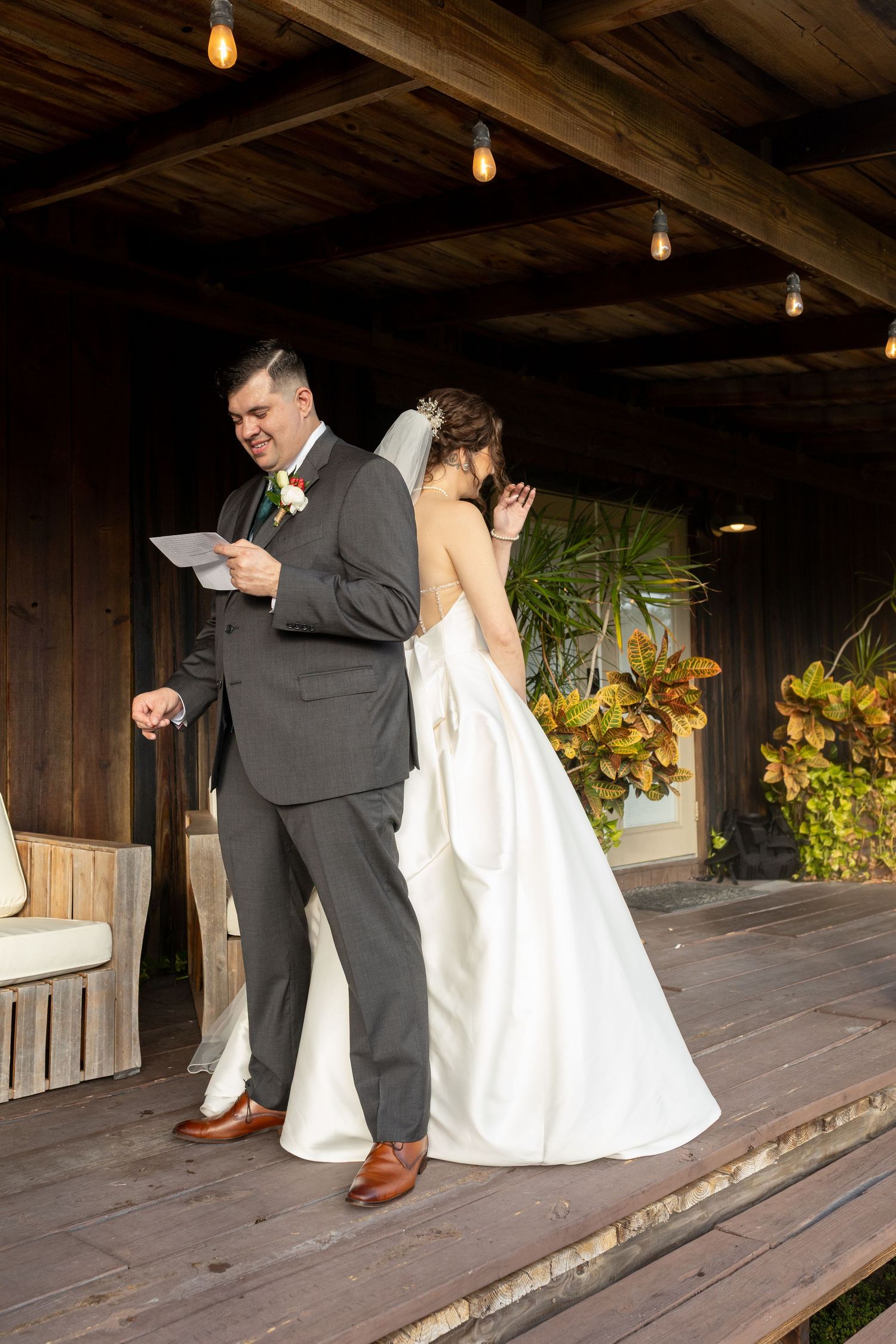 First look moment between couple in a rustic wooden venue with sunflowers.