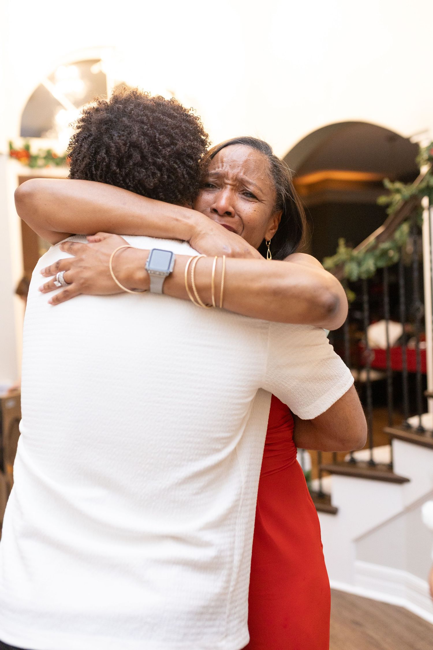 Two people sharing a warm embrace wearing white and red during a holiday photo session.