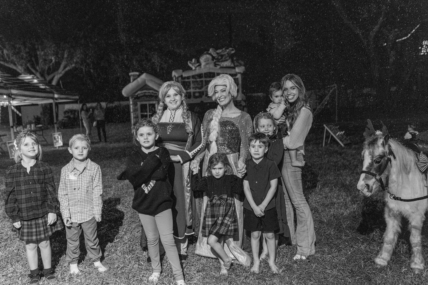 Group of children gathered outdoors in a nighttime setting for a special event.
