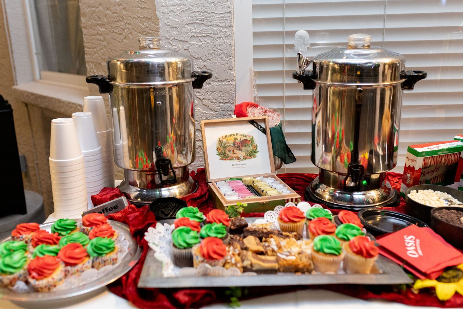 Holiday party buffet table with festive red and green cookies and treats.