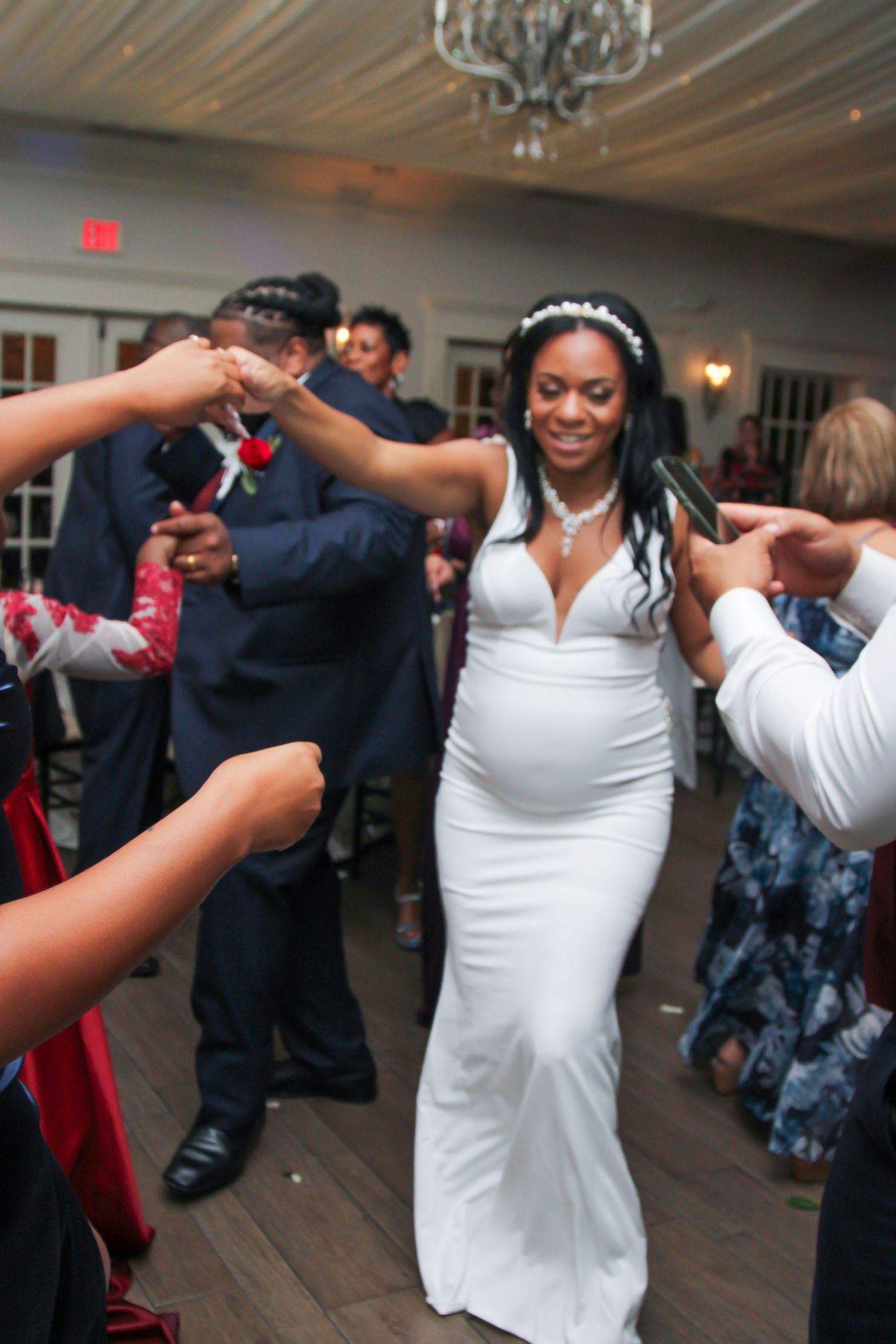 Wedding reception dance floor moments with guests celebrating in indoor venue.