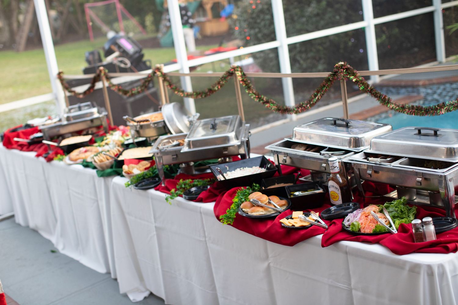 Buffet table with white tablecloth displaying various food dishes and serving stations.