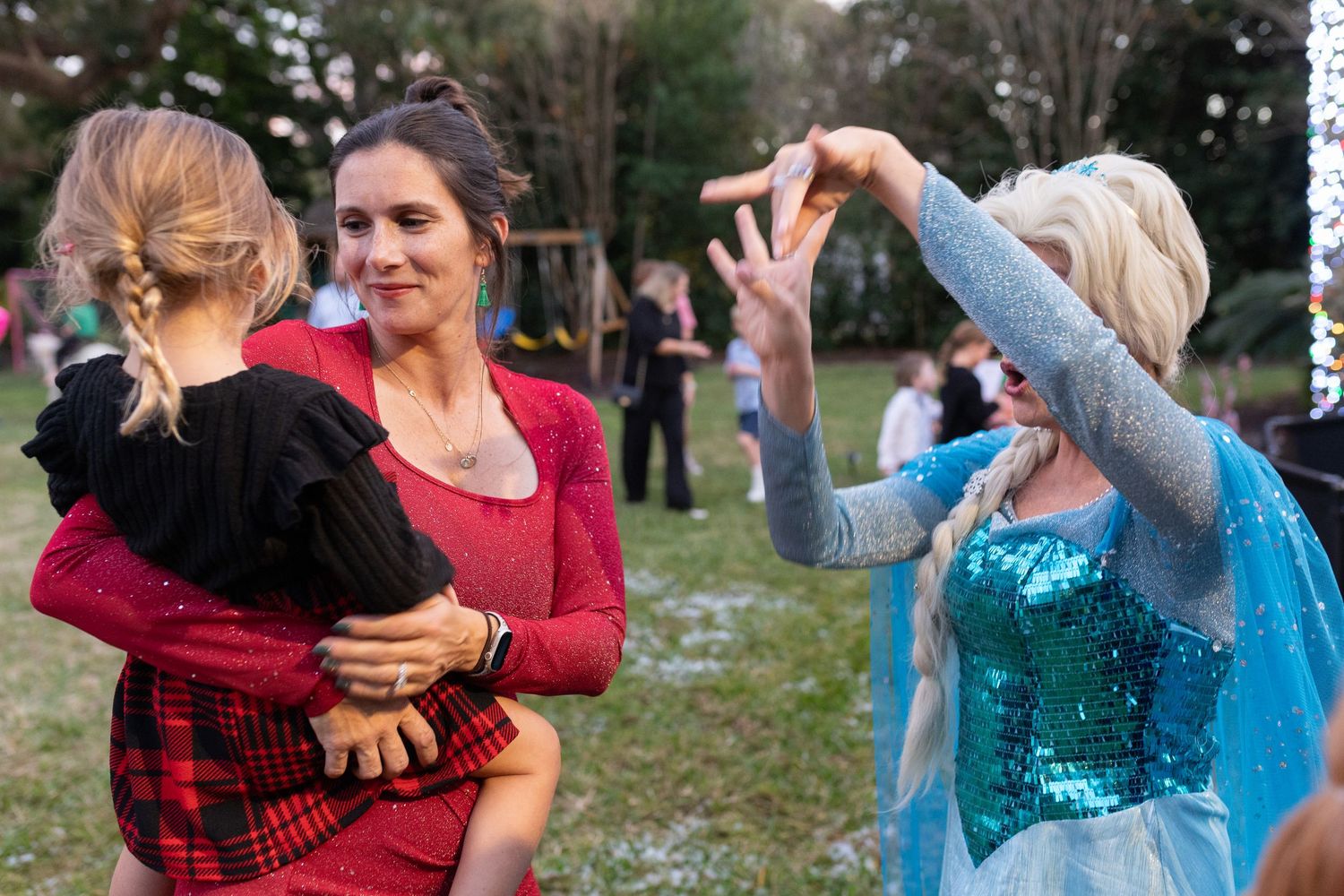 People in festive attire dancing and celebrating at an outdoor gathering.