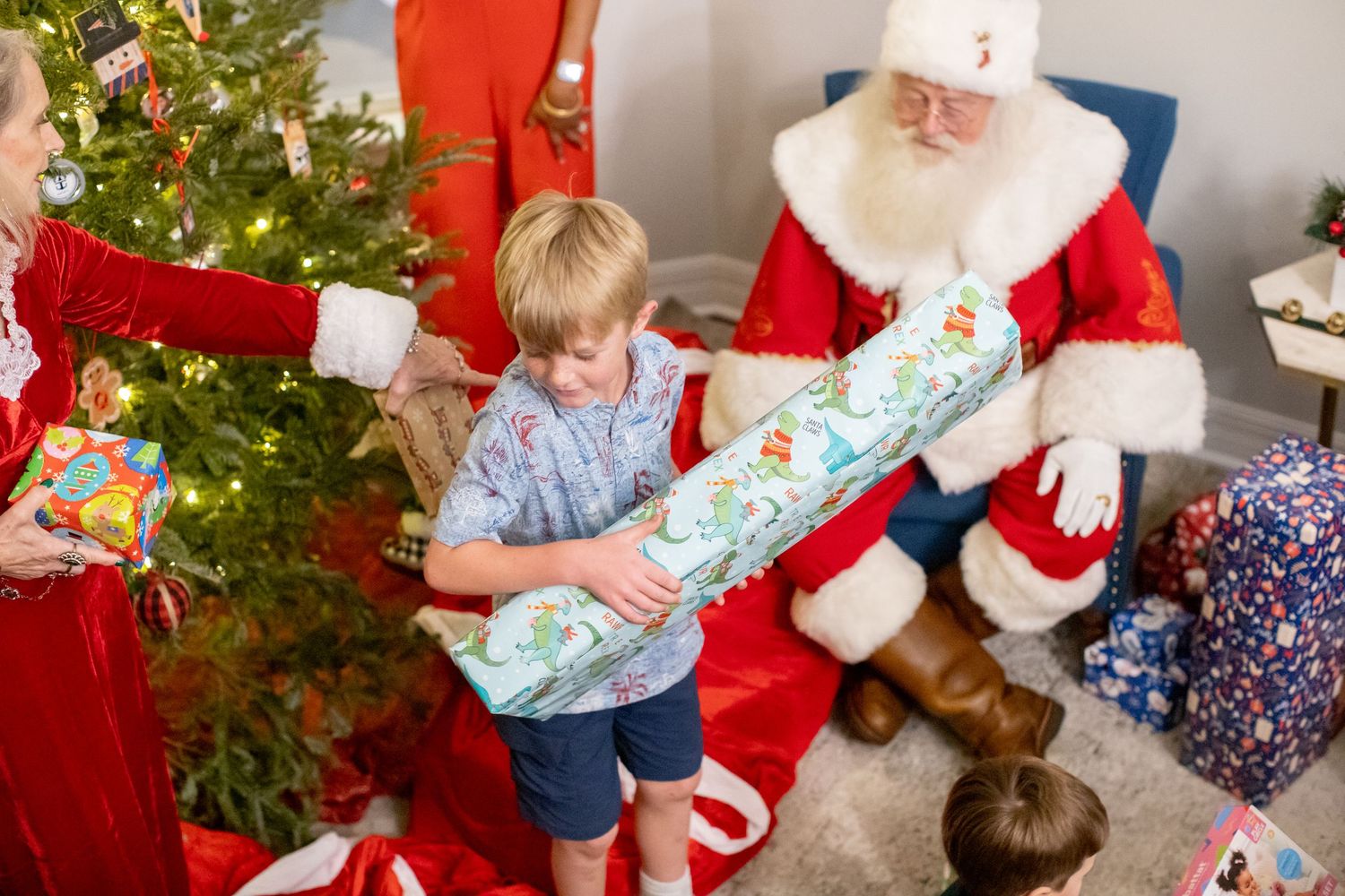 Christmas celebration with decorated tree and festive gathering in a brightly lit room.