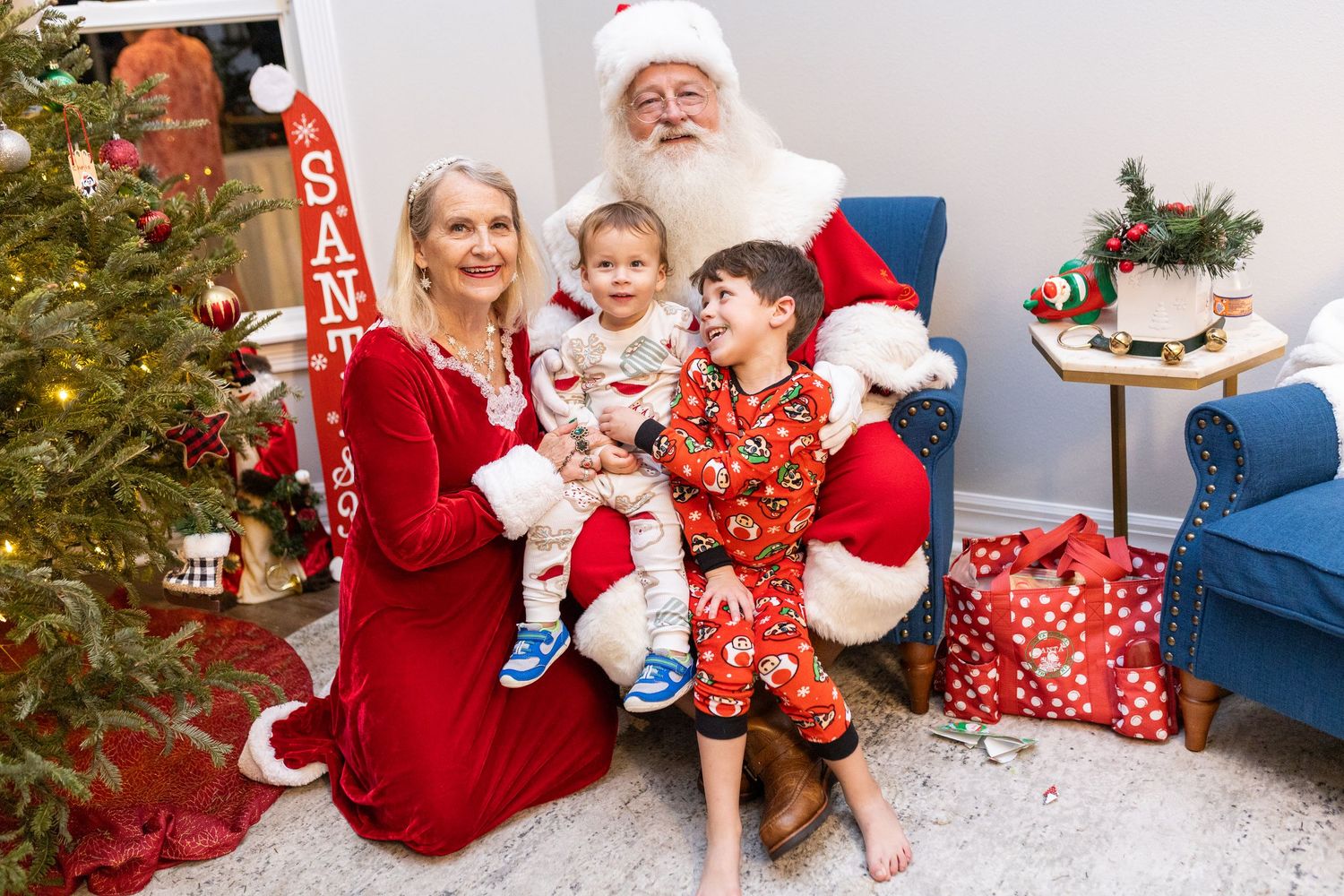 Holiday photo session showing festive decorations and Christmas tree in the background.