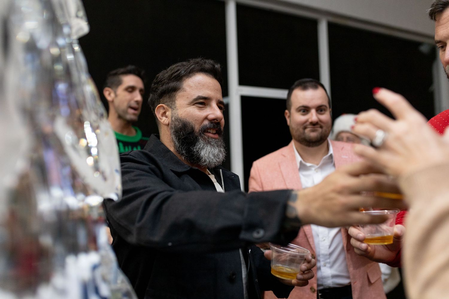 Person reaching for drinks during holiday party celebration.