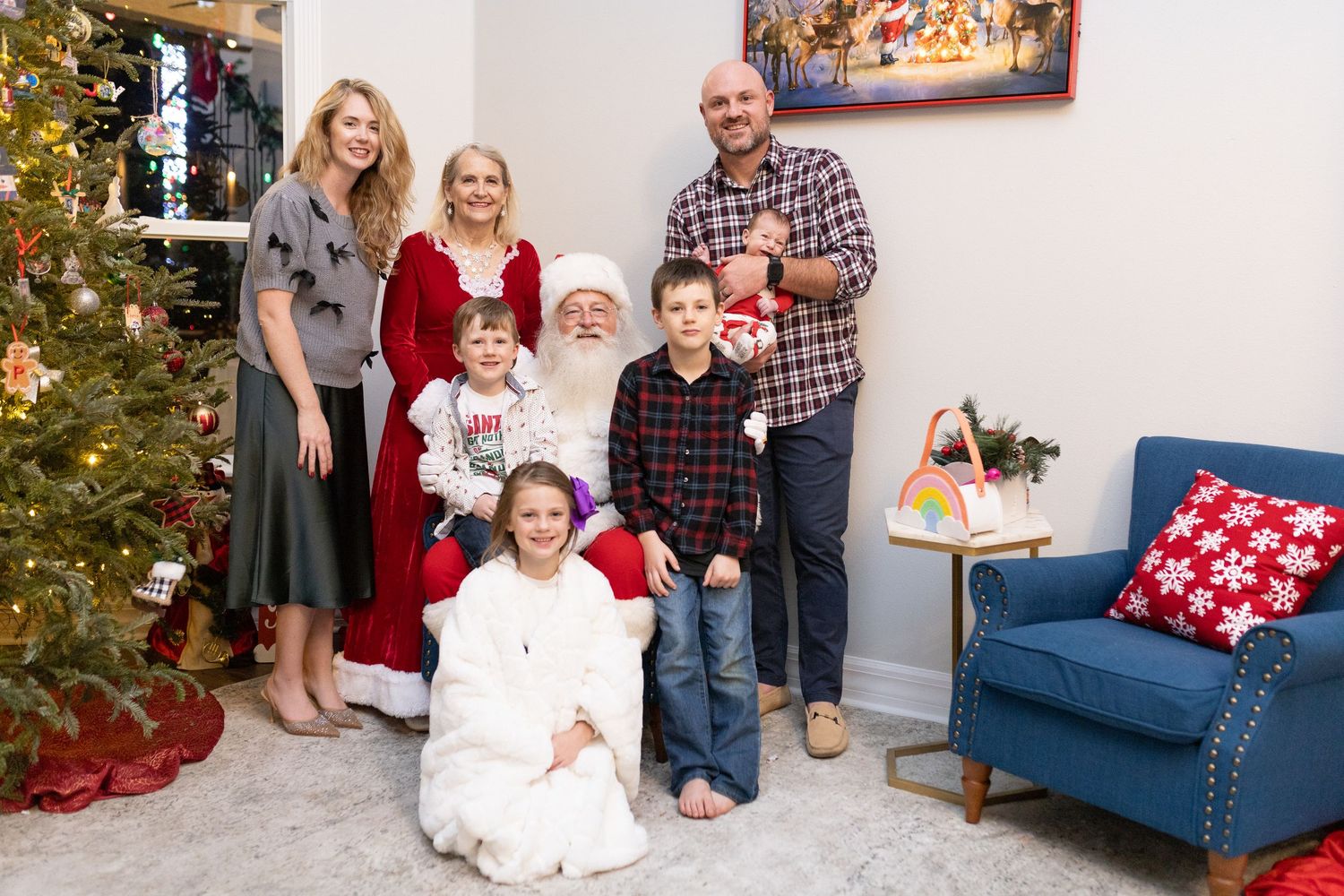 A festive Christmas scene with a decorated tree and blue couch in a bright living room.