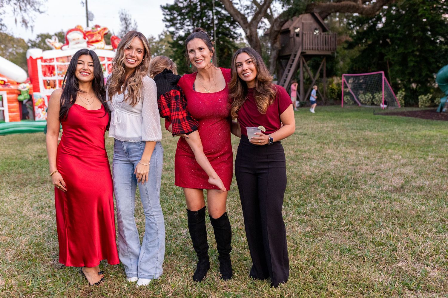 Group photo at an outdoor party with people wearing casual attire standing on grass.