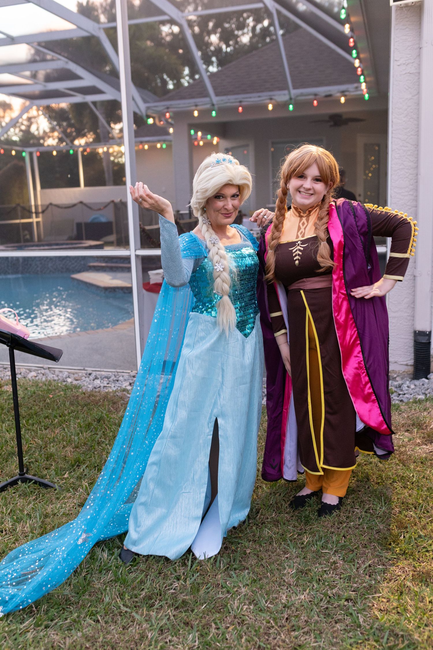 Costumed performers posing under an outdoor pergola with string lights.