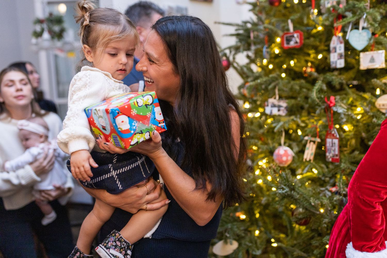 A touching holiday moment as parent and child examine a Christmas gift together.