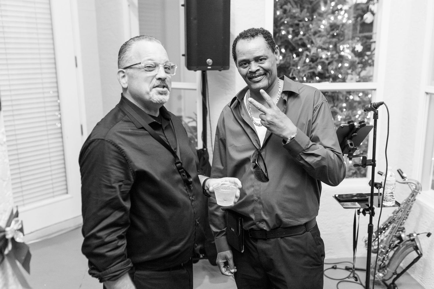 Two men share a candid moment in black and white photography.