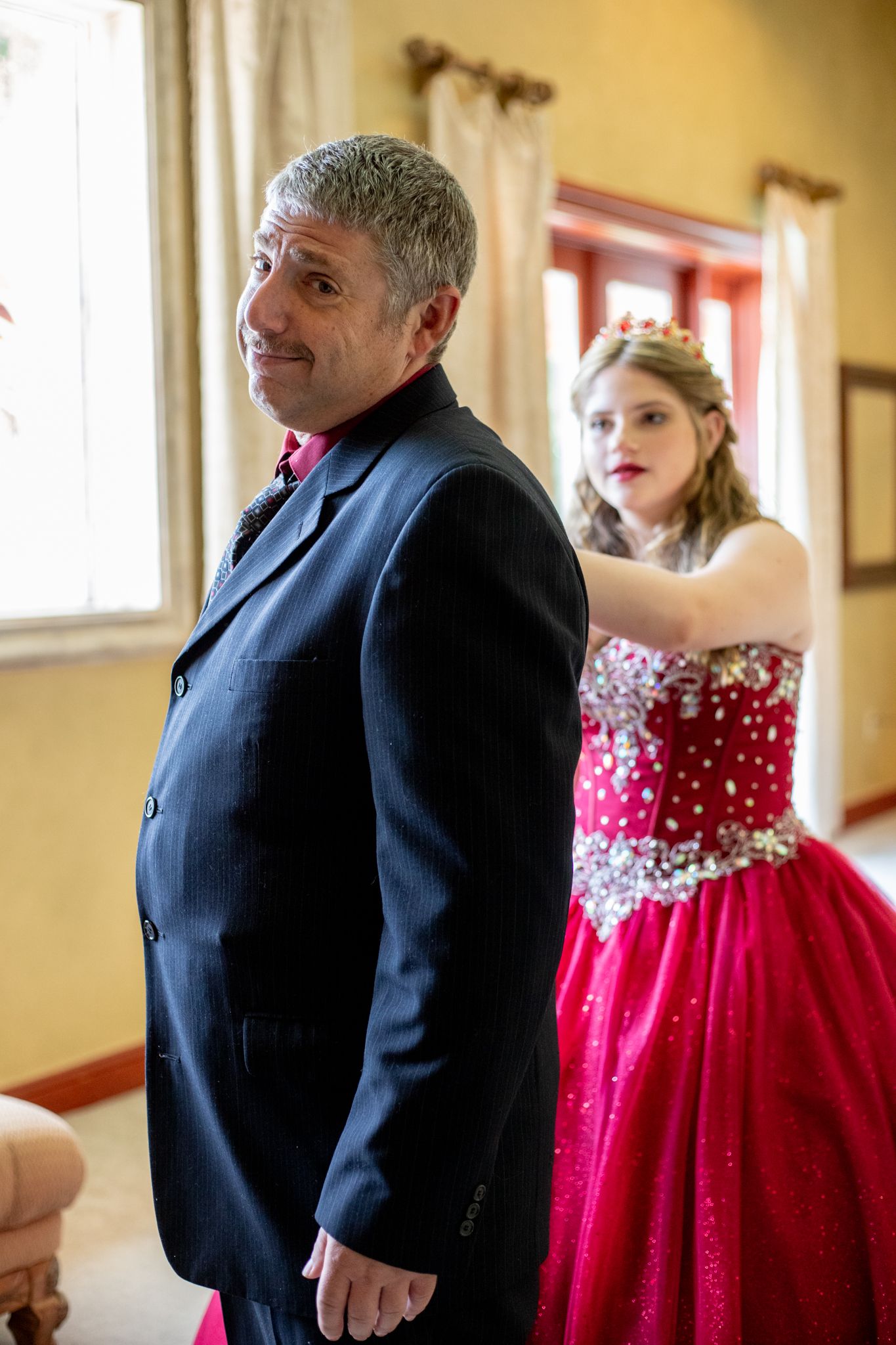 Candid moment during formal event with red ballgown and navy suit.