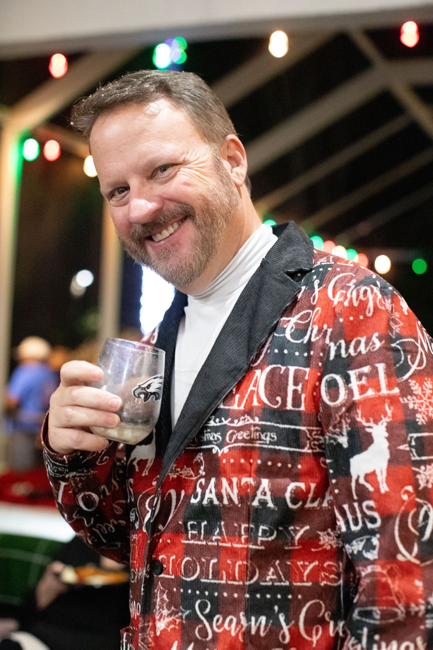 Person wearing a festive red holiday sweater with white text decorations.