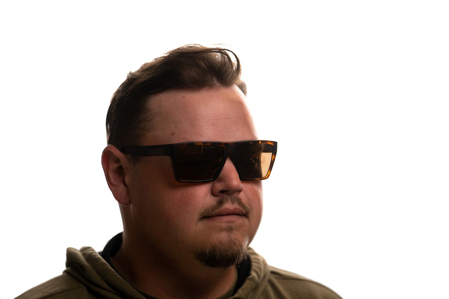 Man with sunglasses in a studio-style portrait on a white background.