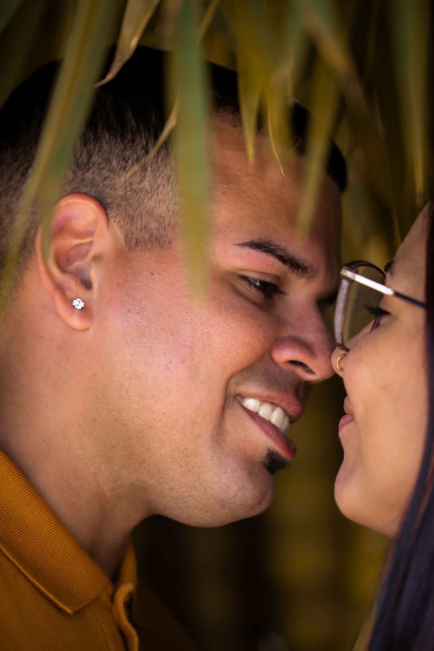 Couple sharing an intimate forehead-to-forehead moment under soft light.