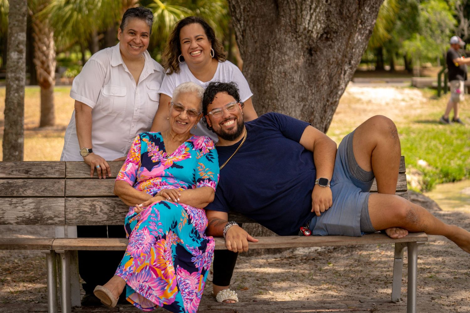 Fun family group sitting on a bench with playful poses and colorful outfits.