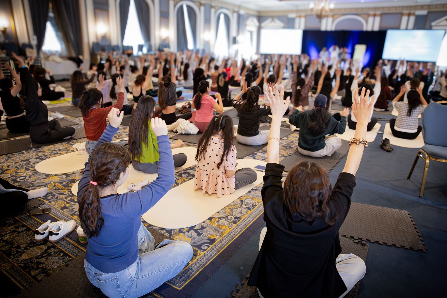 Participants raising their hands during a wellness retreat photography session in Ottawa