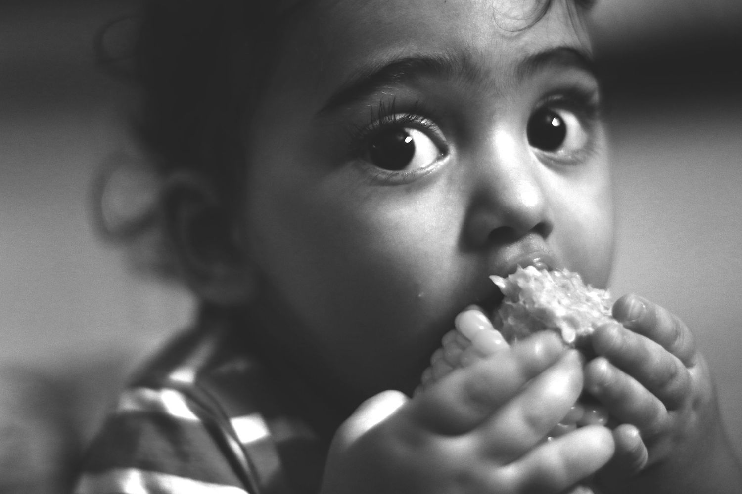 Black and white portrait of a child with wide curious eyes